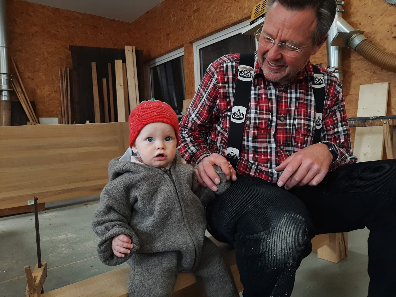 Jens-Uwe Korn mit seinem Enkelkind in der Werkstatt